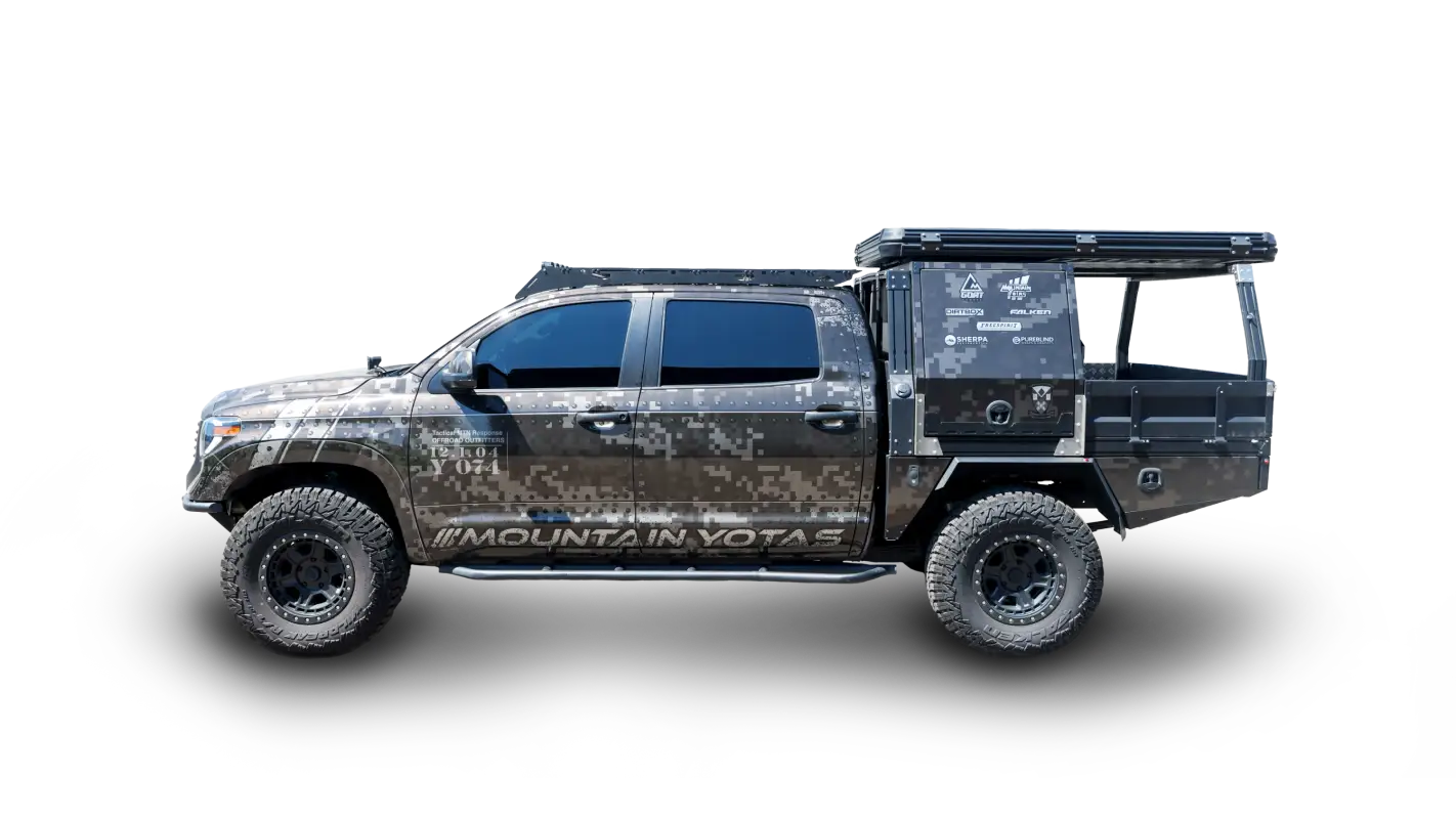Toyota Tundra CrewMax with Big Bear Roof Rack in camo wrap, featuring aluminum construction and secure crossbars for cargo storage.