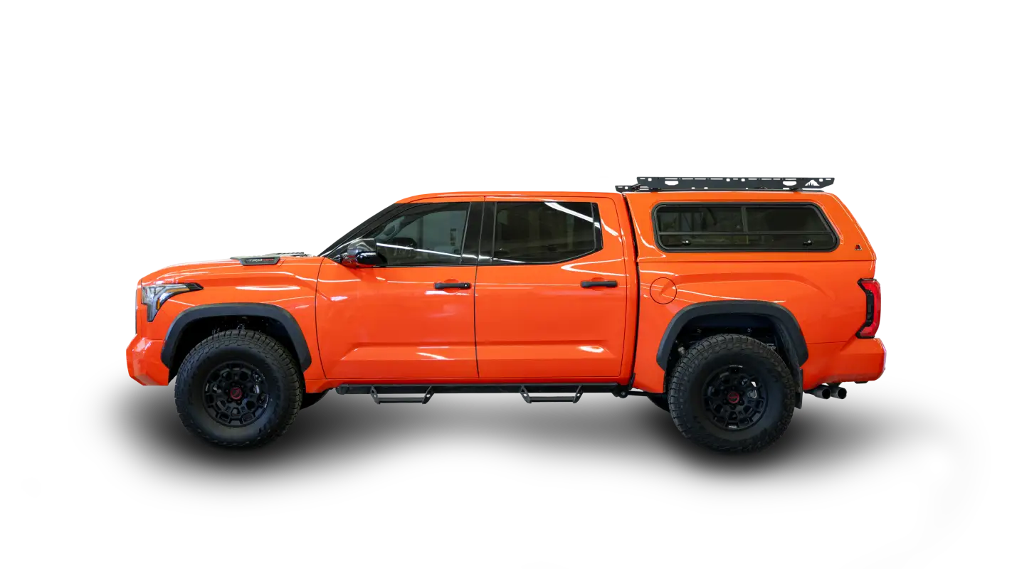 Bright orange truck equipped with the Crow’s Nest aluminum roof rack topper, designed for secure gear storage and no-drill installation.