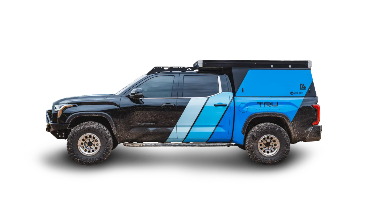 Side view of a black and blue Toyota Tundra equipped with The Cub Roof Rack and camper setup, ideal for outdoor storage and solar panel mounting.