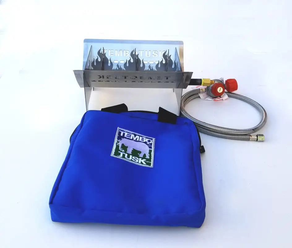 TemboTusk Fire Pit assembled with stainless steel panels and burner, displayed alongside its blue carry bag for easy portability.