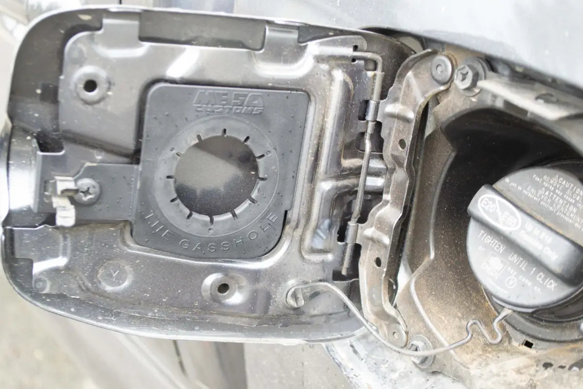 The Gasshole - Tacoma 16-23 installed in a fuel door, showcasing its precise fit and compatibility with OEM/Aftermarket caps.