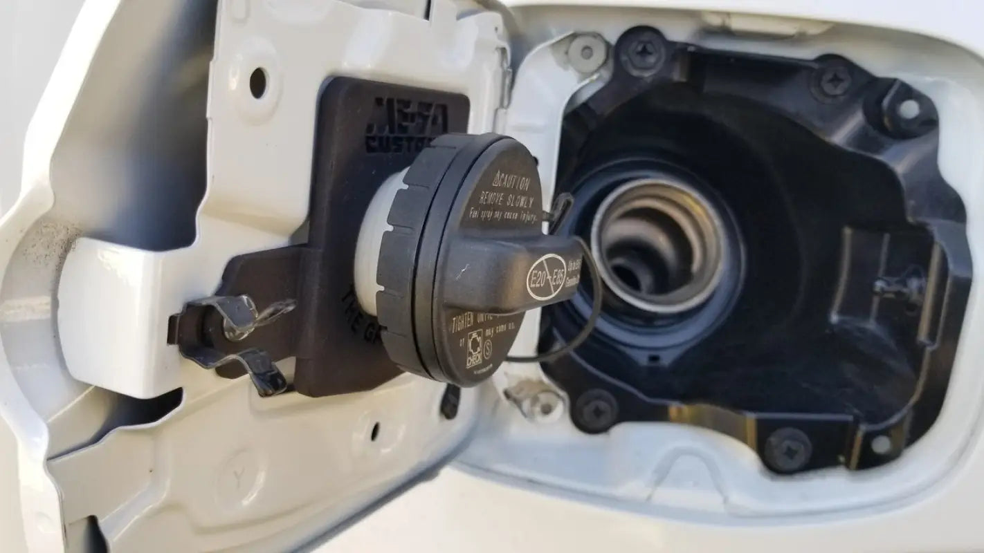 The Gasshole - Tacoma 16-23 installed in a white vehicle's fuel door, demonstrating its secure fit and durable construction.