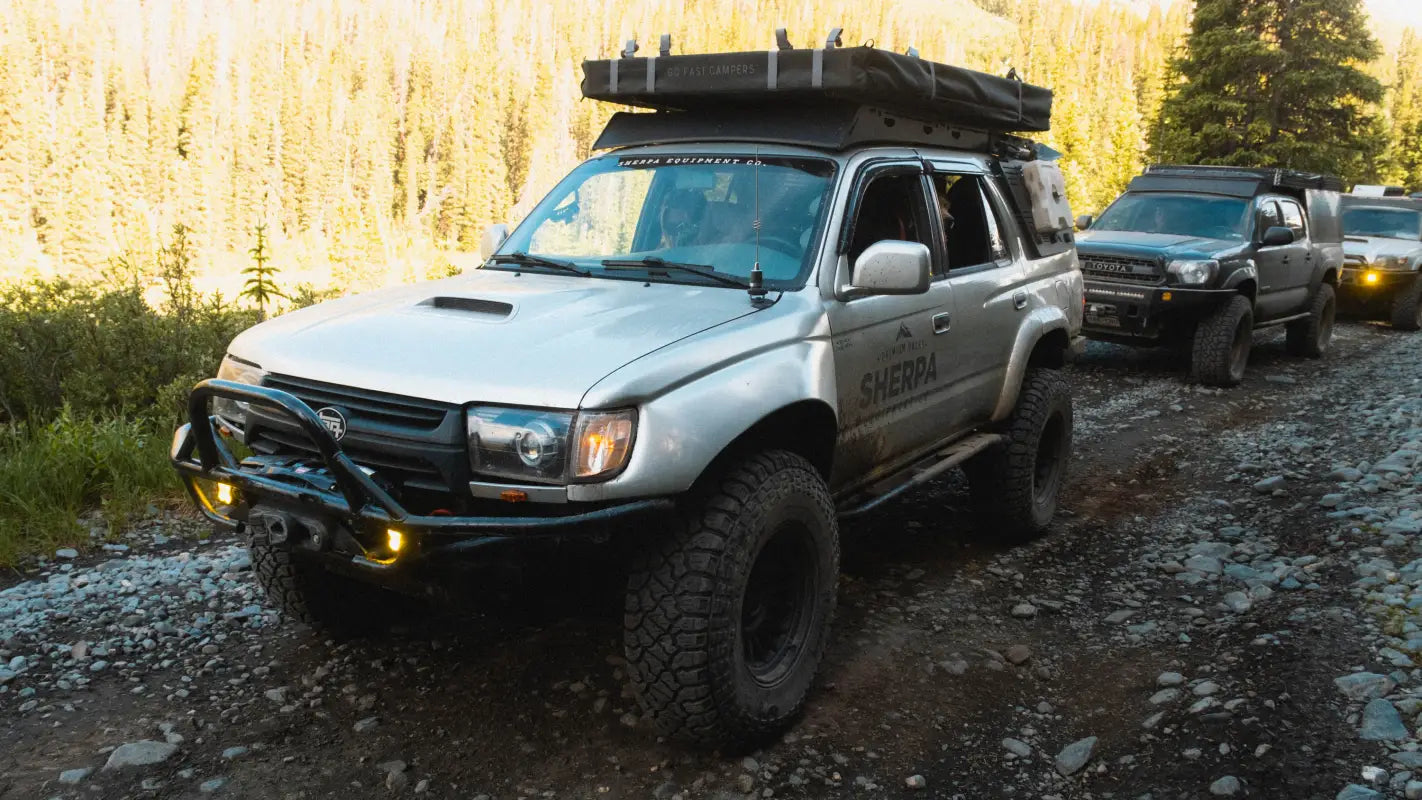 Toyota 4Runner equipped with Matterhorn roof rack and off-road gear, driving on a rocky trail in a forest setting.
