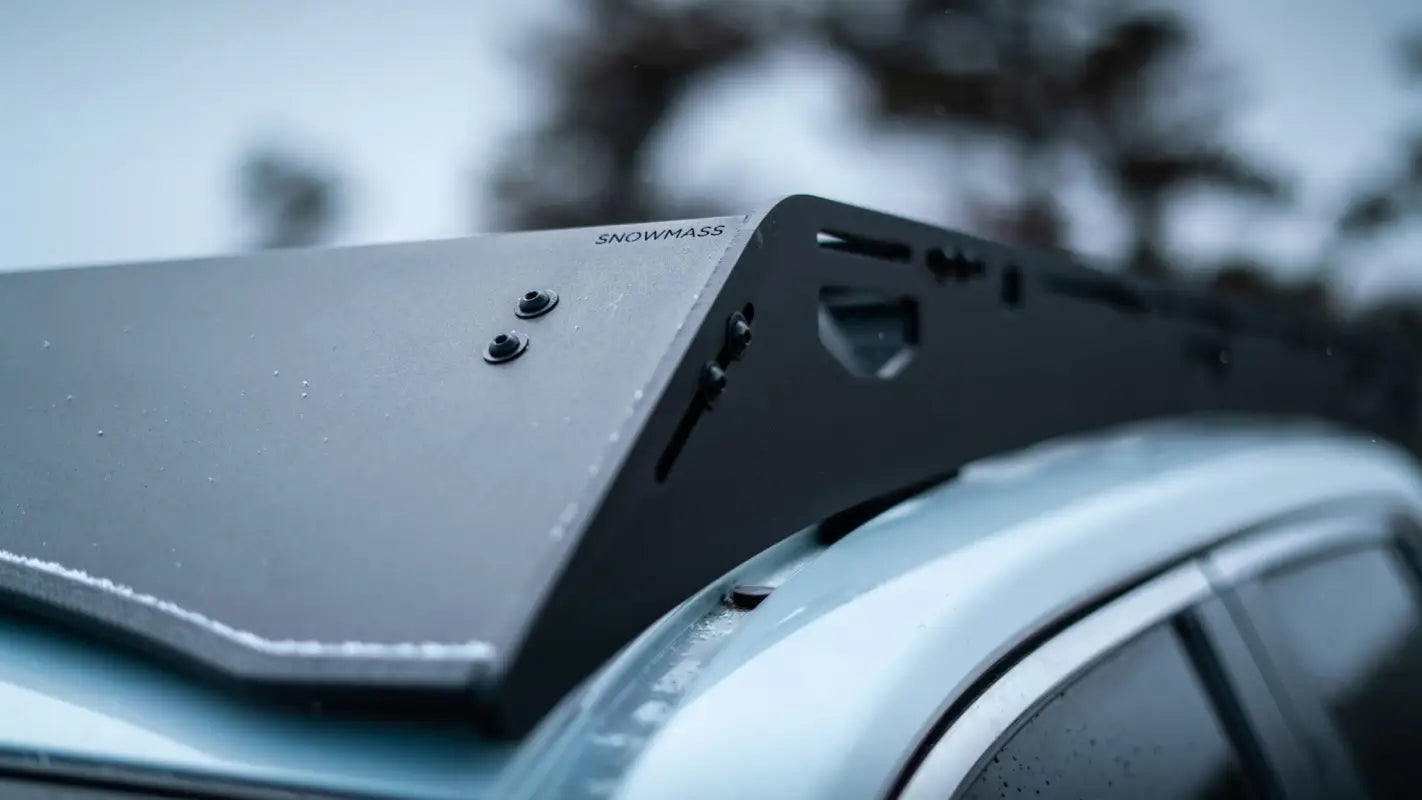 Close-up of The Snowmass roof rack's black aluminum frame on a gray RAV4, showcasing its rigid design and mounting points.