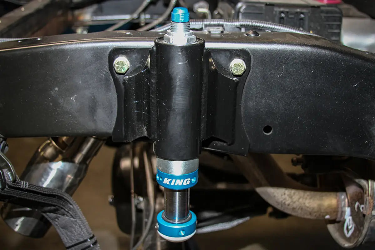 King 2.0 bump stop installed on a Toyota Tacoma frame using TOTAL CHAOS bolt-on mounting kit for improved suspension performance.