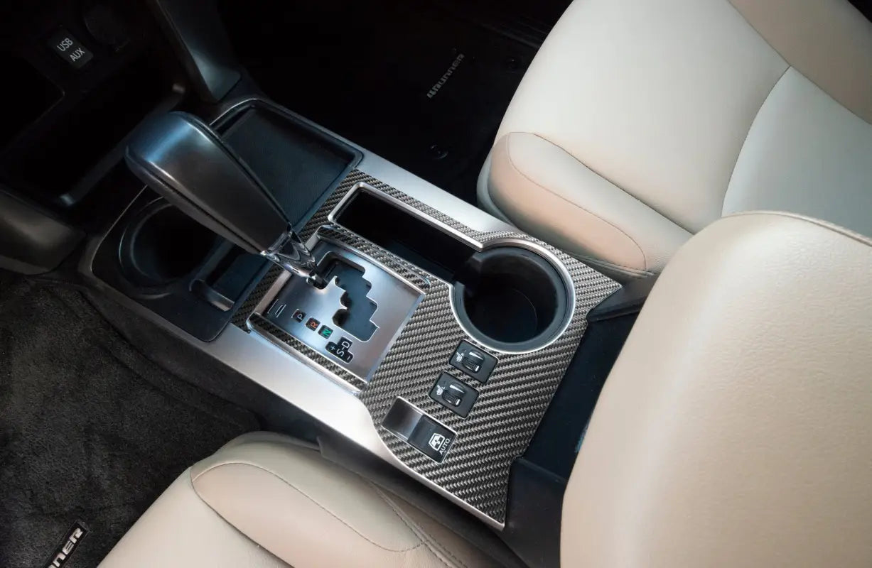 Close-up view of carbon fiber-style transmission console accent trim fitted in a Toyota 4Runner, showcasing a sleek and modern design.