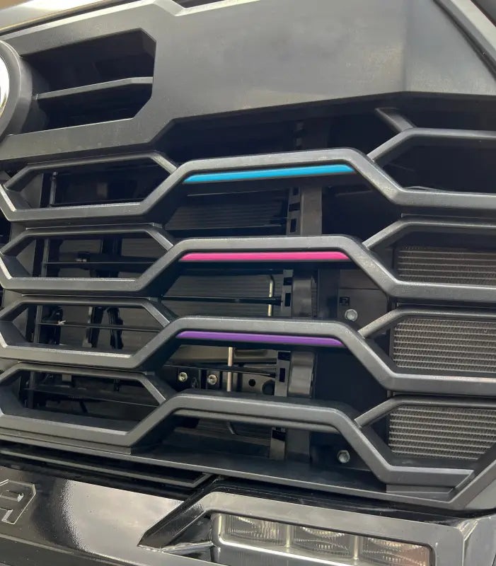 TRD grille line inserts in blue, pink, and purple installed on a Toyota Tundra or Sequoia grille for a vibrant look.