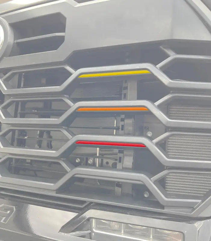TRD grille tri-color line inserts in yellow, orange, and red installed on a 2022-2024 Toyota Tundra or 2023-2024 Toyota Sequoia grille.