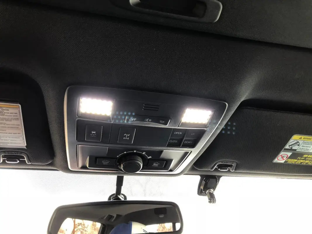 Bright white Ultimate Map Lights illuminating the interior of a 16-23 Tacoma, mounted on the overhead console.