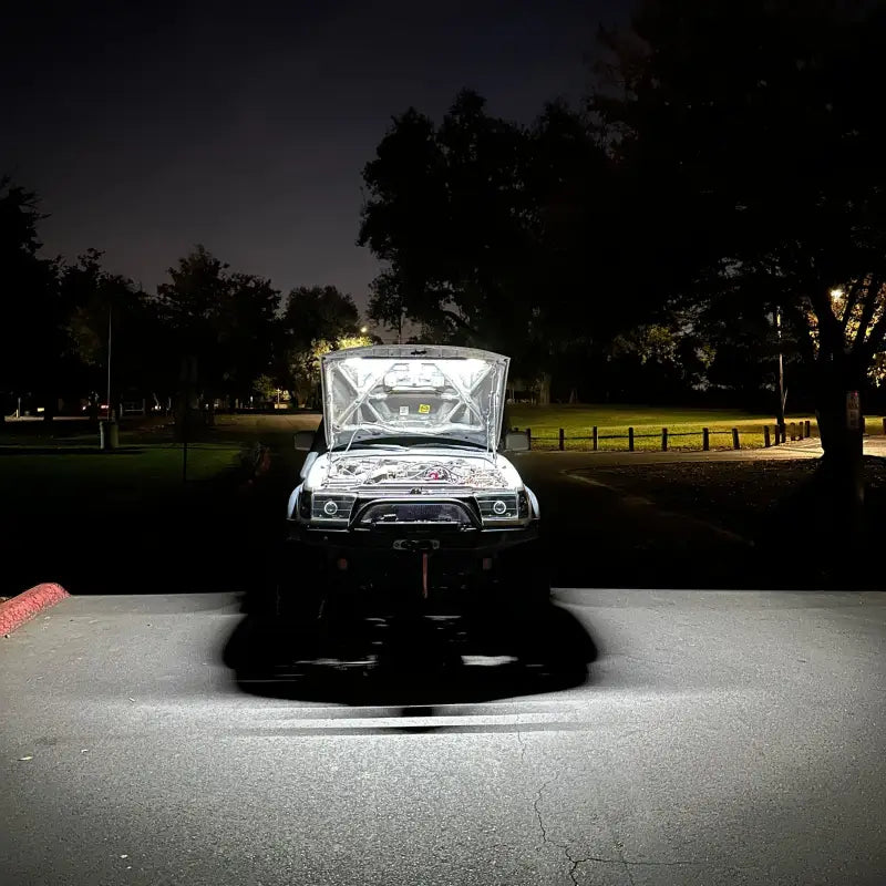 Toyota truck with an illuminated engine bay at night, highlighting the bright and efficient under hood LED light kit.
