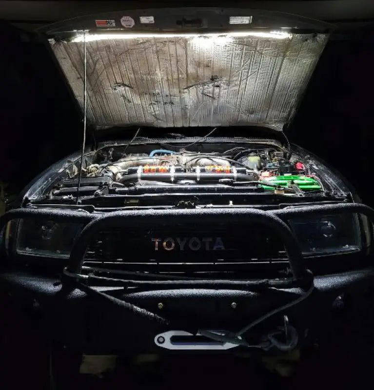 Toyota truck engine bay illuminated by the under hood LED light kit, showcasing its bright and even lighting for maintenance.