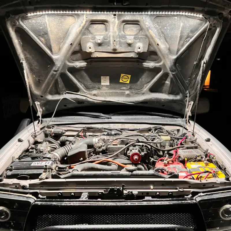 Toyota truck engine bay brightly lit by the under hood LED light kit, highlighting its 40-inch LED strip and 1,300-lumen output.