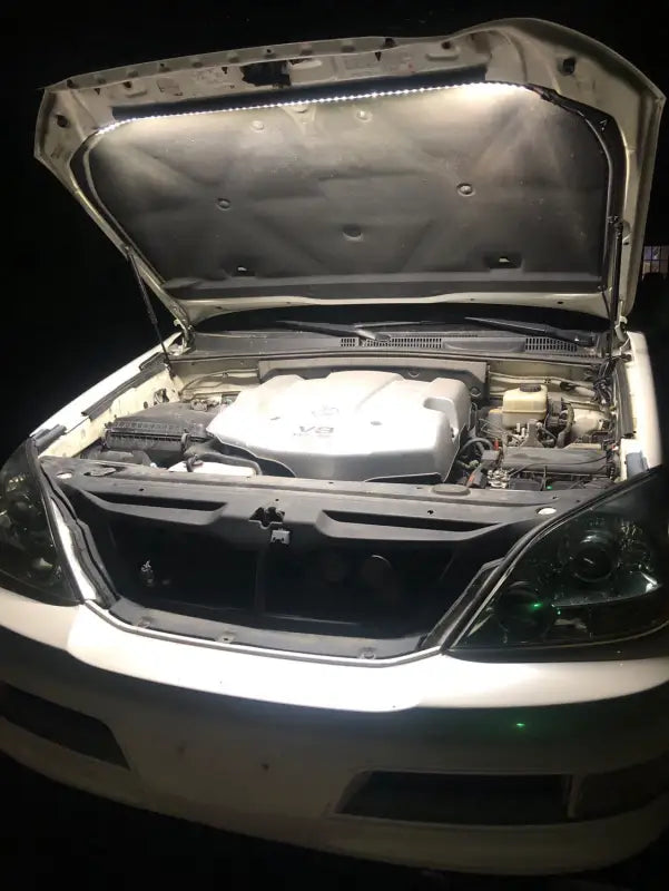 Engine bay of a Toyota SUV illuminated by the under hood LED light kit, providing clear visibility for nighttime maintenance.