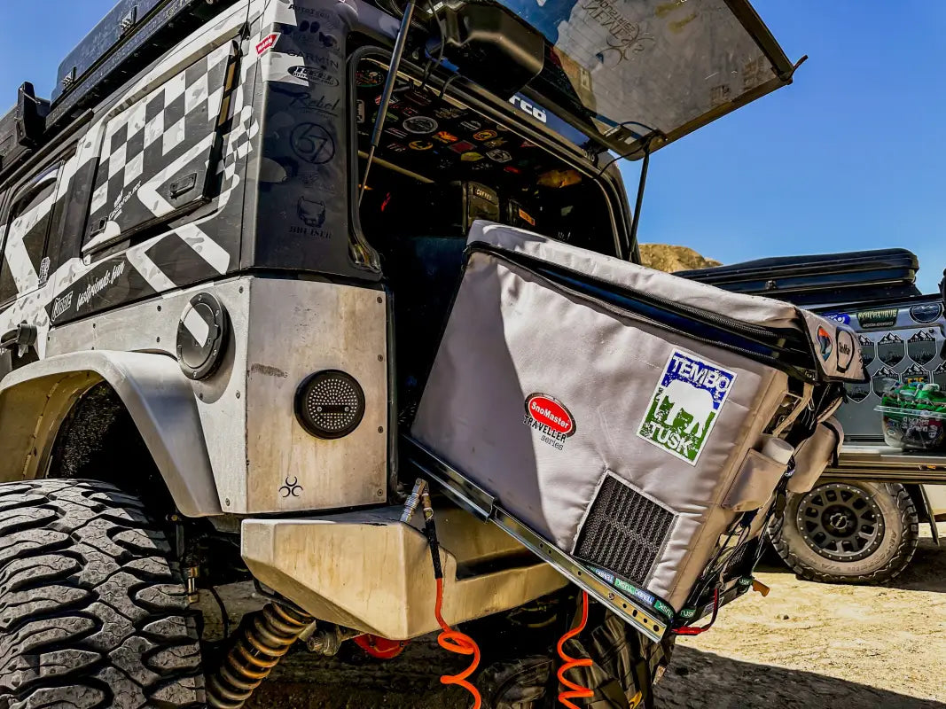 Universal Tilt Slide Adapter installed on an off-road vehicle, supporting a fridge at a 28° tilt for easy access during camping.