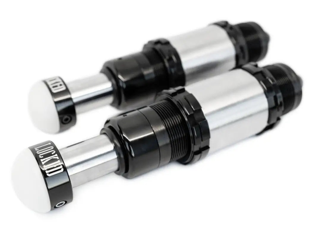 Pair of 2.0-inch threaded bump stops with adjustable travel, robust black and silver build, ideal for off-road vehicle suspension upgrades.