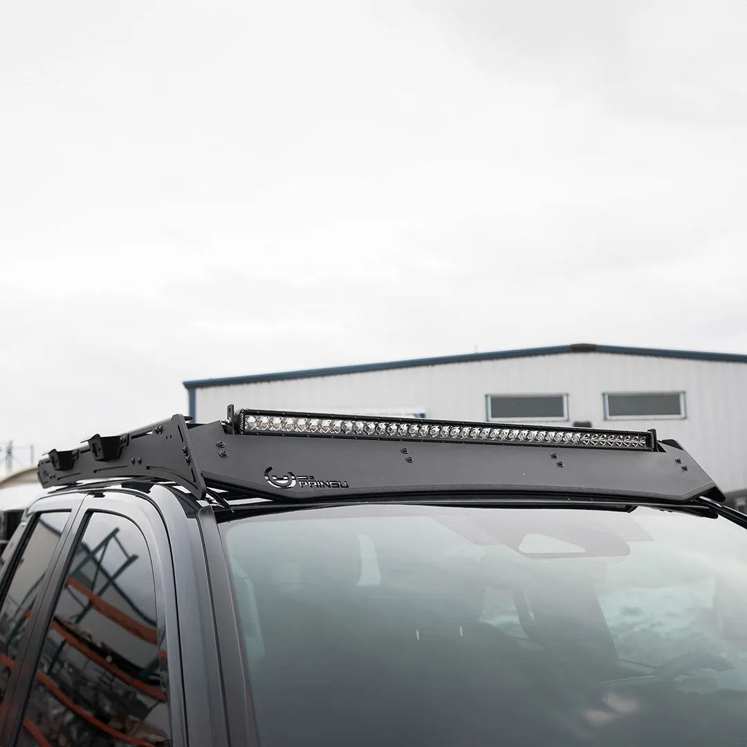 Close-up of Prinsu Pro Cab Roof Rack mounted on a Toyota Tacoma, featuring an integrated light bar and aerodynamic design for reduced wind noise.