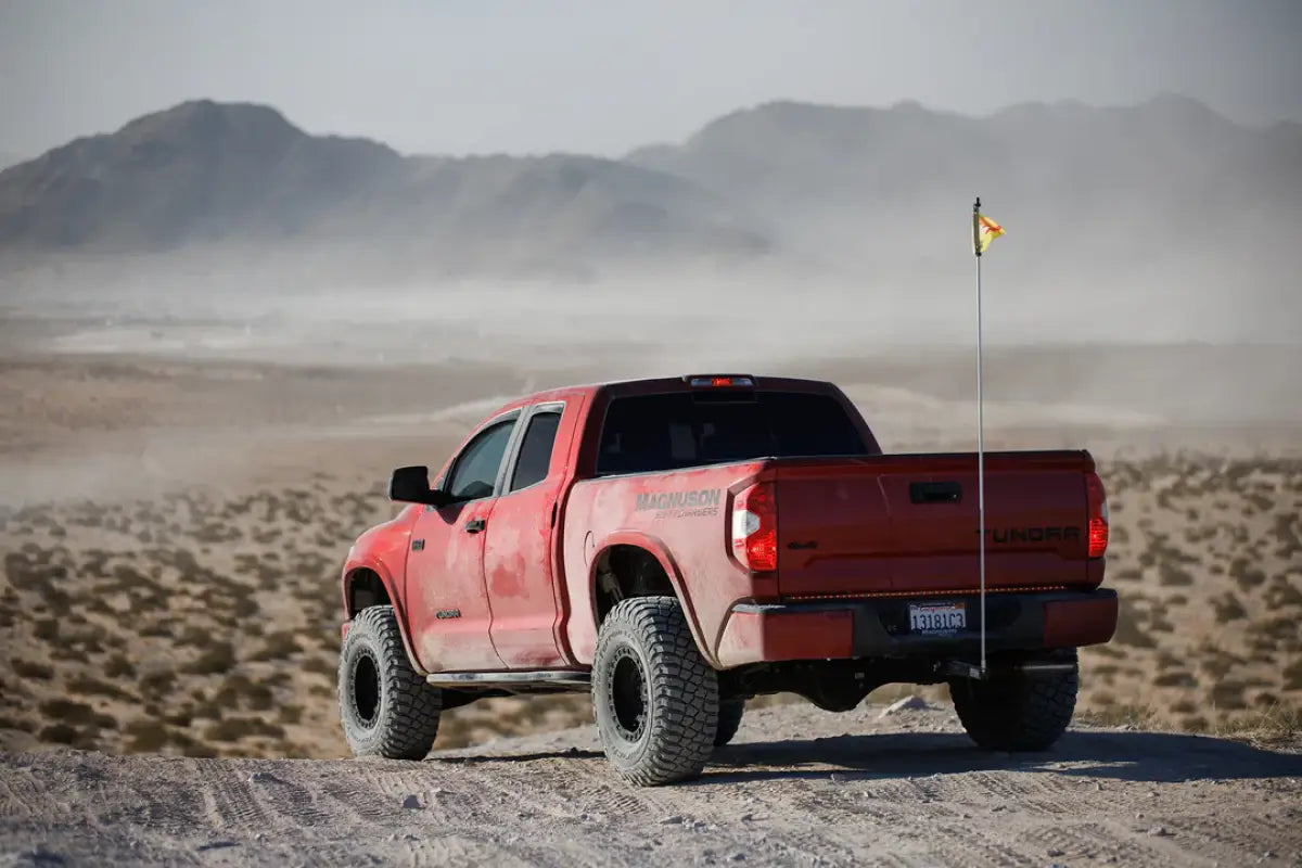 Rear view of a red Toyota Tundra with the 19-21 Magnum Supercharger System TVS2650, set against a rugged desert backdrop.