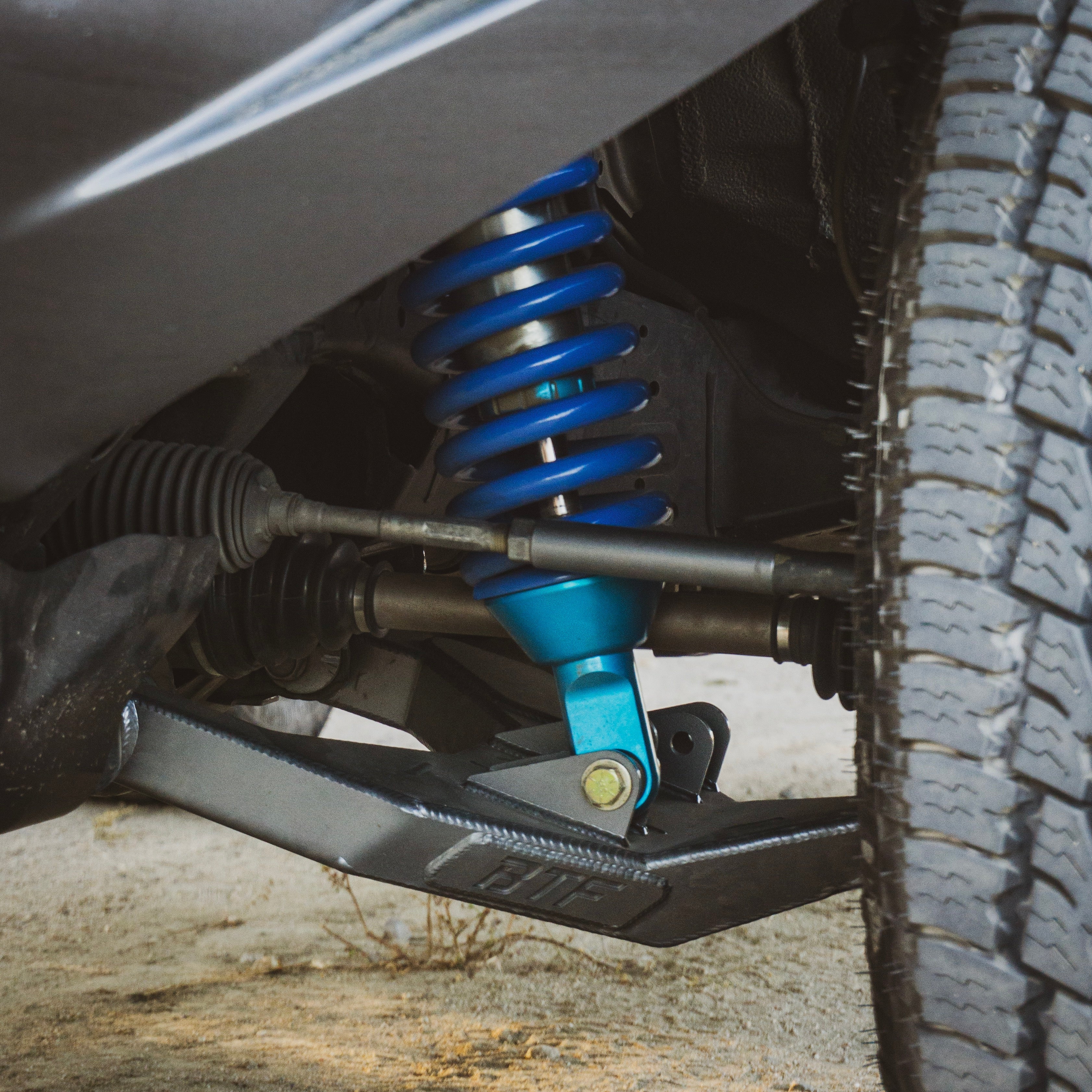 Close-up of long travel suspension on a 5th Gen 4runner / GX460 with blue coil springs and reinforced control arms.