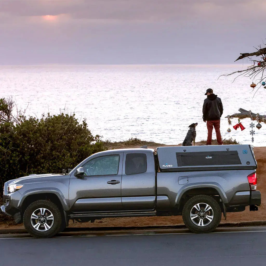 Mid-size truck with an inflatable truck cap parked by the ocean, emphasizing its versatility for outdoor adventures and camping.