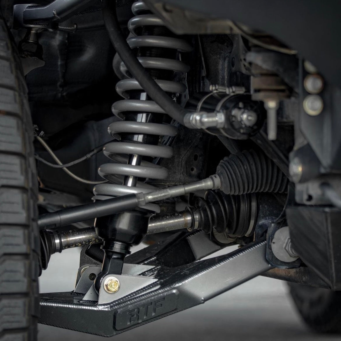 Close-up view of 5th Gen 4runner / GX460 long travel suspension system, highlighting coil springs, control arms, and CV axles.