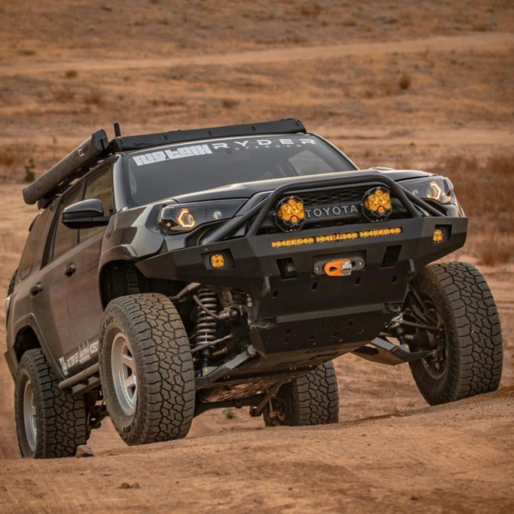 5th Gen 4runner with GX460 long travel suspension navigating off-road terrain, showcasing enhanced ground clearance and rugged modifications.