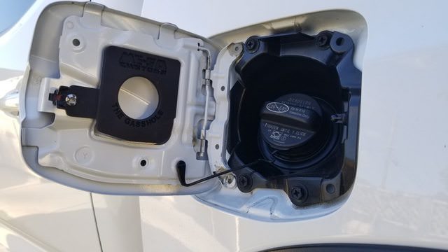 Close-up of The Gasshole gas cap holder installed on a Toyota Tacoma, demonstrating its seamless integration with the fuel door.