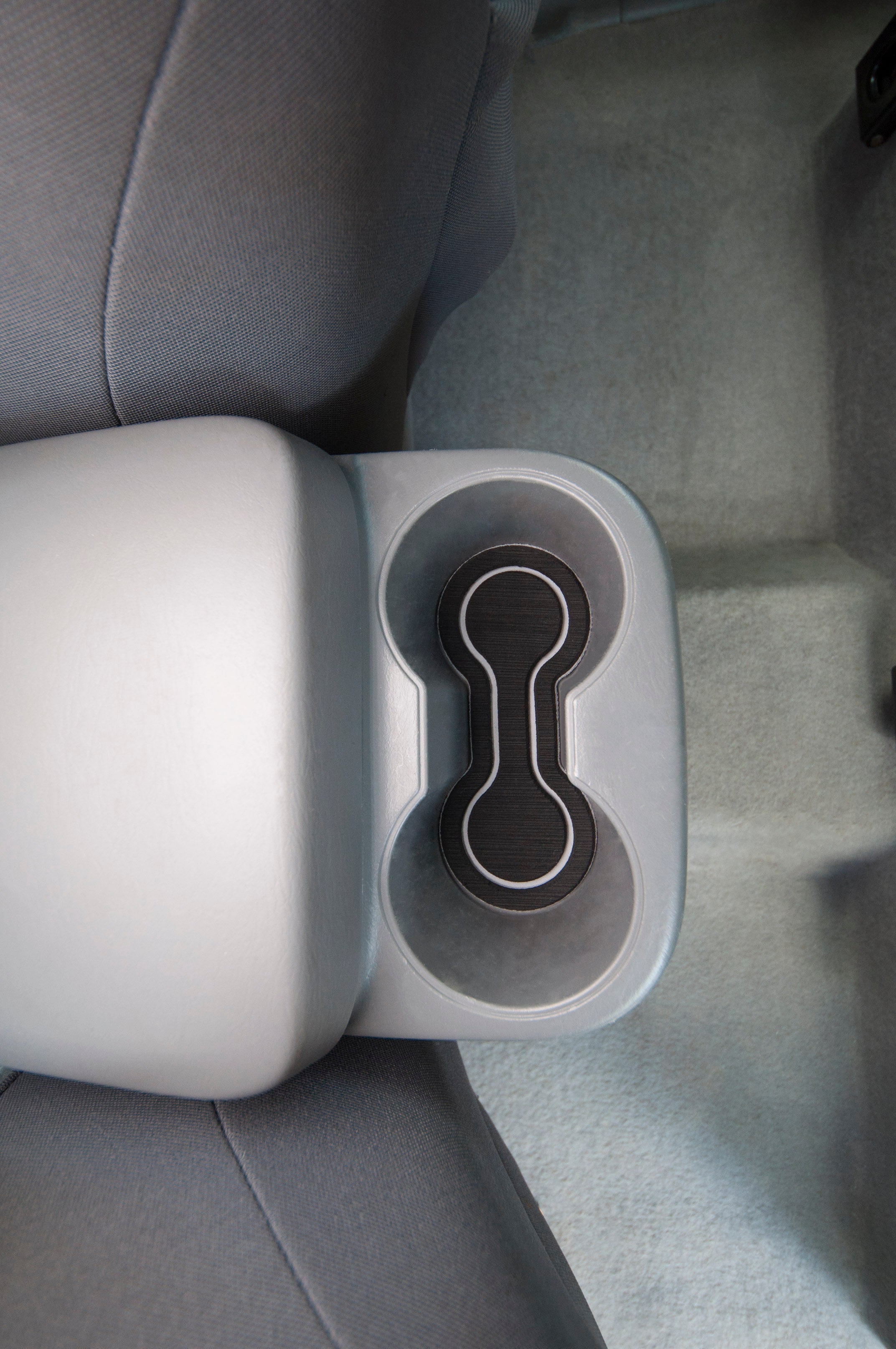 Foam cup holder inserts placed in the rear cup holder section of a Toyota Tacoma, offering a snug fit and improved interior decor.