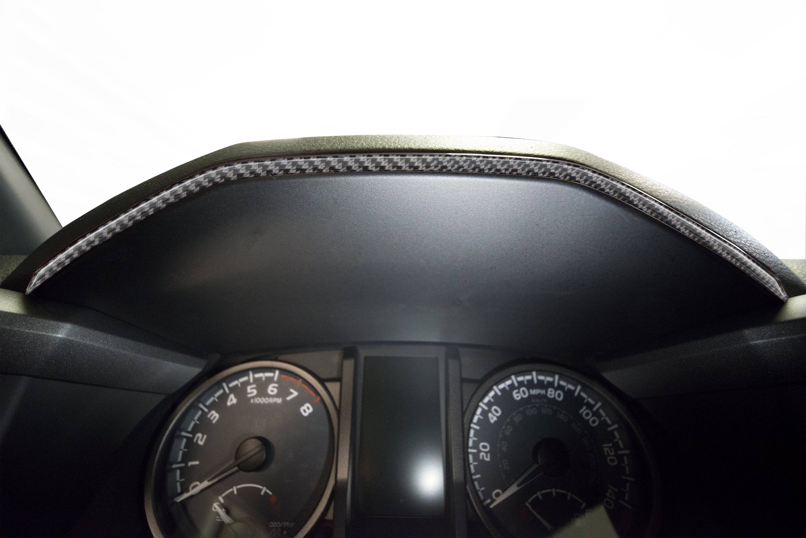 Close-up view of a carbon fiber textured dashboard accent overlay fitted on a 2016-2023 Toyota Tacoma, showcasing precise fit and finish.