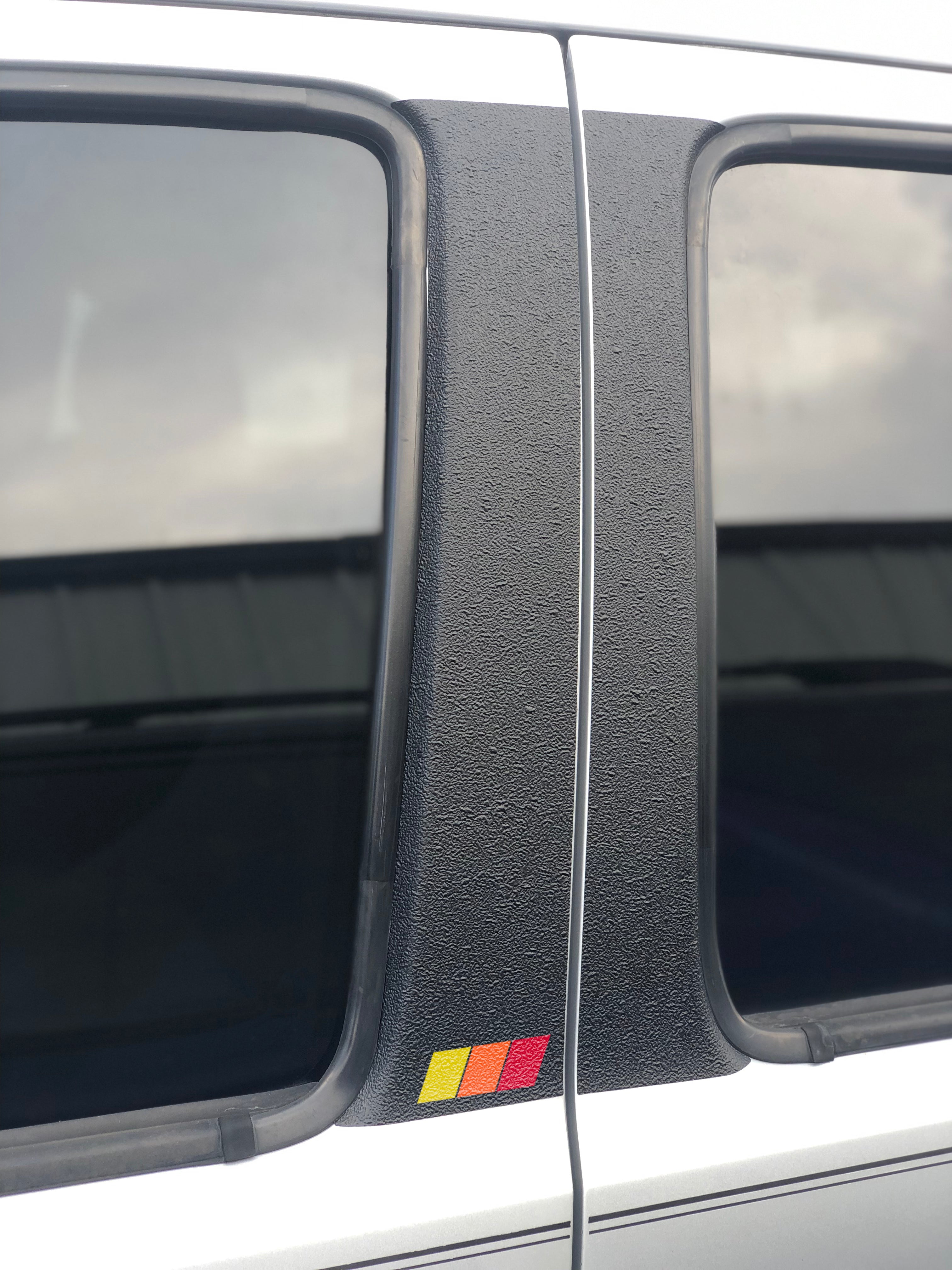 Close-up of textured door pillar overlay with tri-color accents in red, yellow, and orange, compatible with Toyota Tacoma 2005-2015.