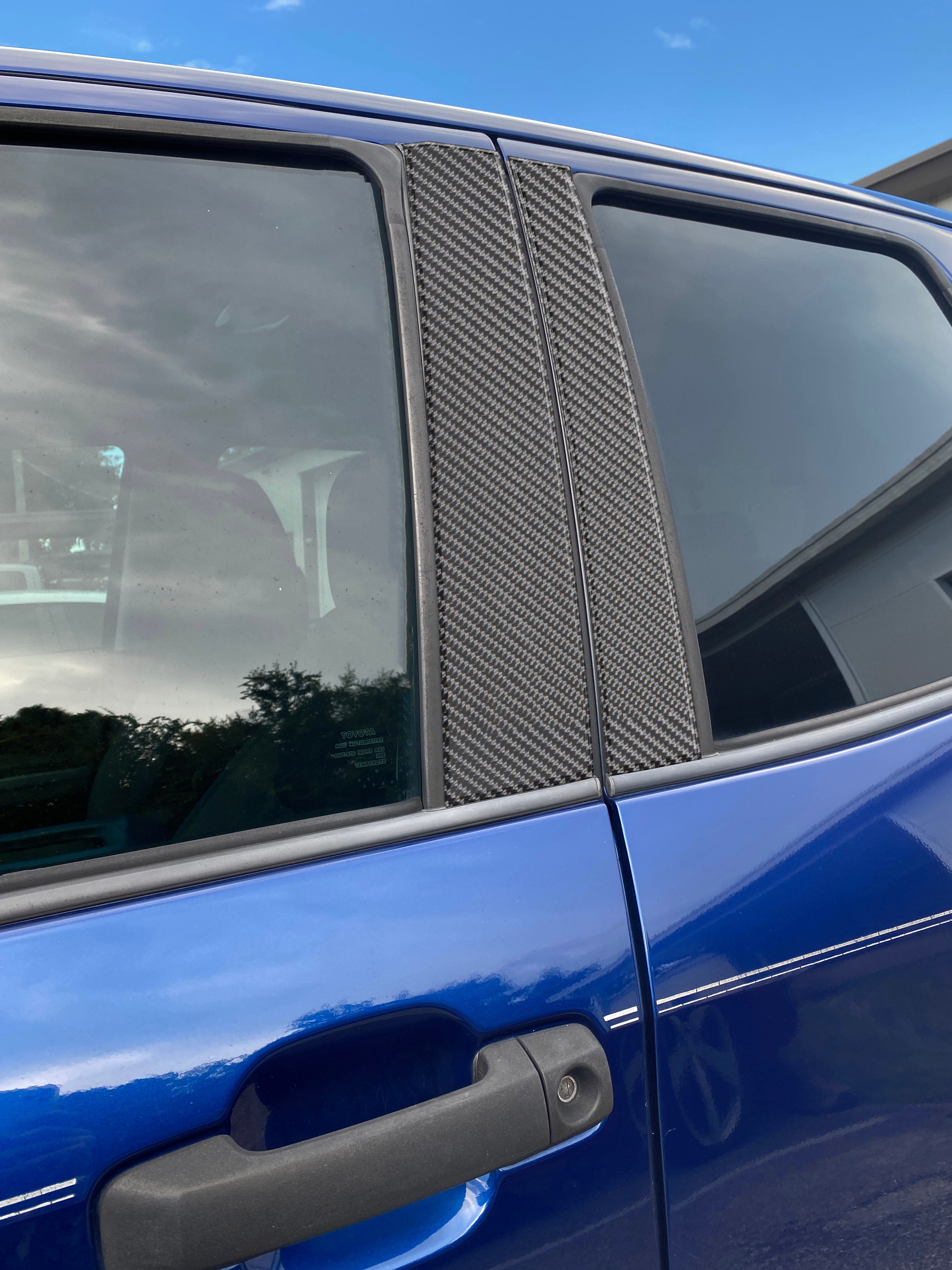 Close-up of carbon fiber-style door pillar accent trim on a blue Toyota Tundra, showcasing precise fit and sleek design.