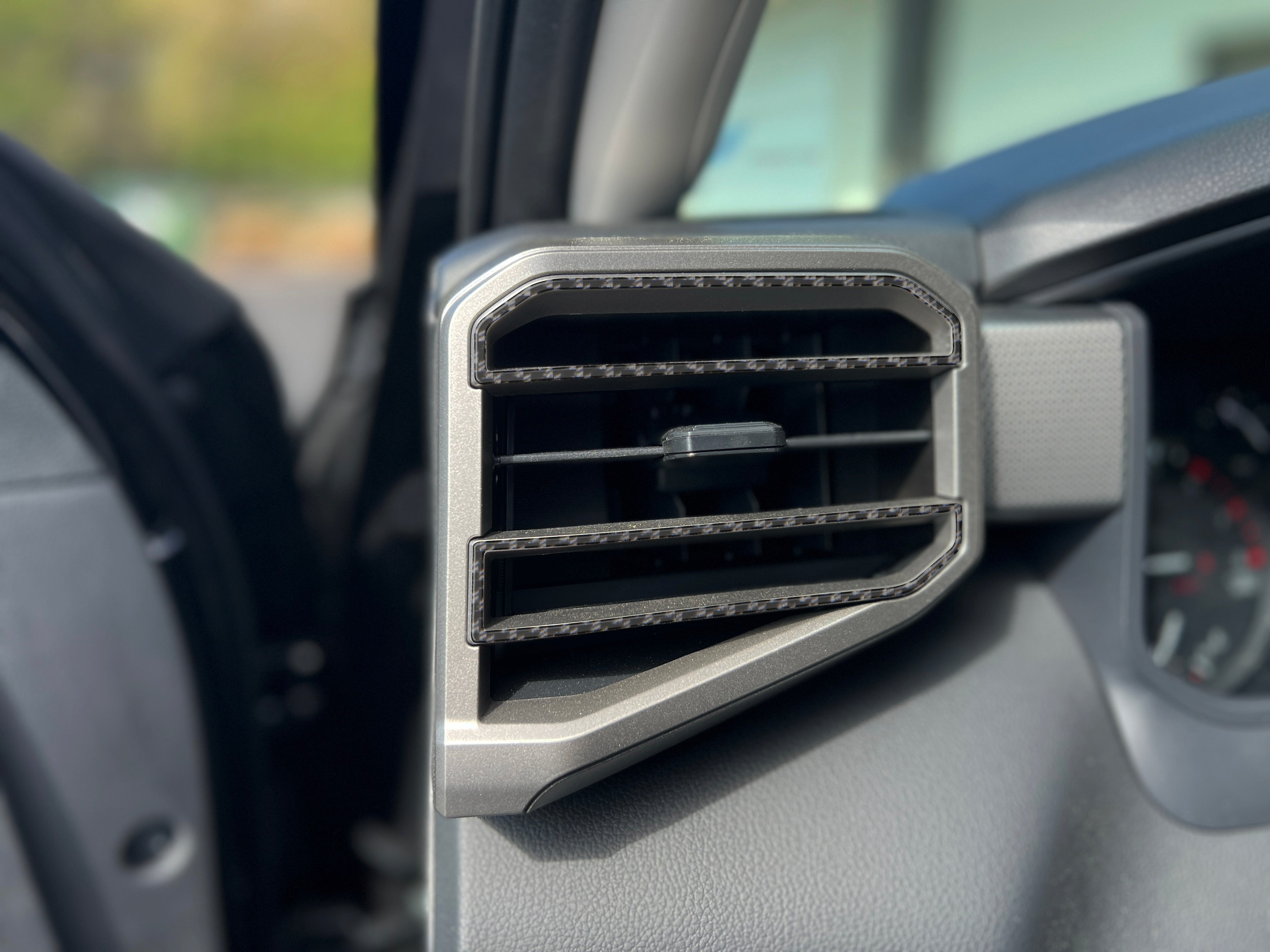 Close-up of A/C vent accent trim fitted on a Toyota Tundra or Sequoia, showcasing a sleek carbon fiber finish for a modern interior look.