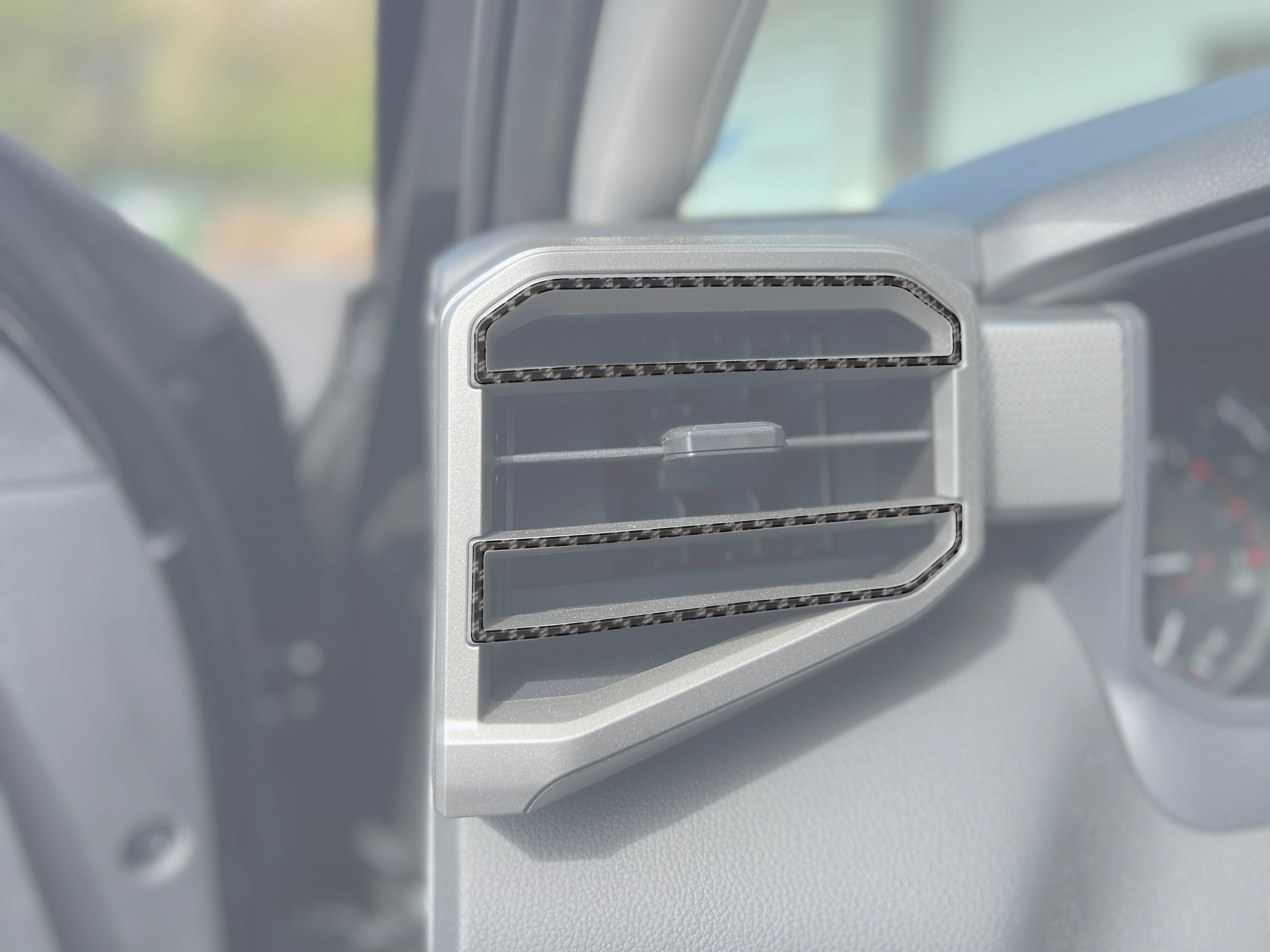 A/C vent accent trim installed on a 2022-2024 Toyota Tundra or 2023-2024 Toyota Sequoia, featuring a carbon fiber design for interior enhancement.