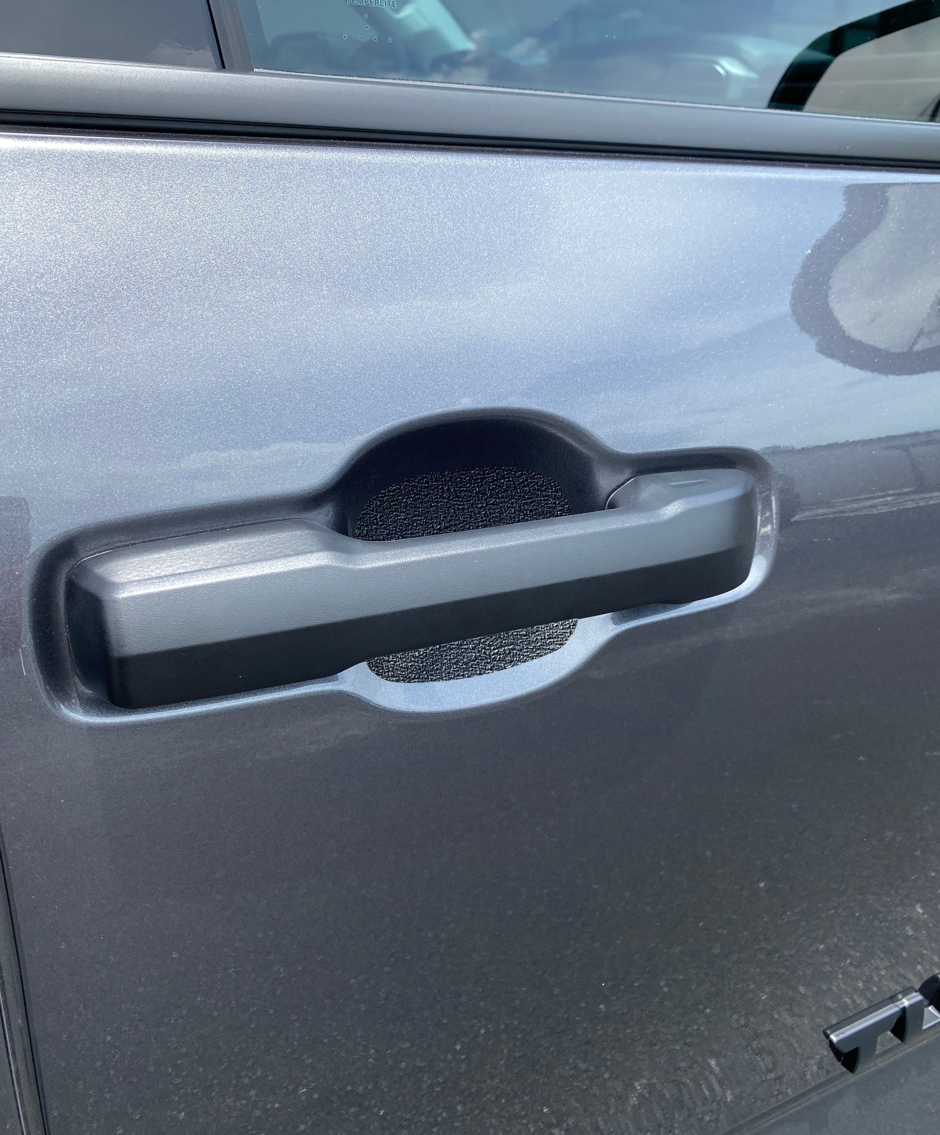 Textured protective door handle insert installed on a dark gray 2022-2024 Toyota Tundra, providing scratch resistance.