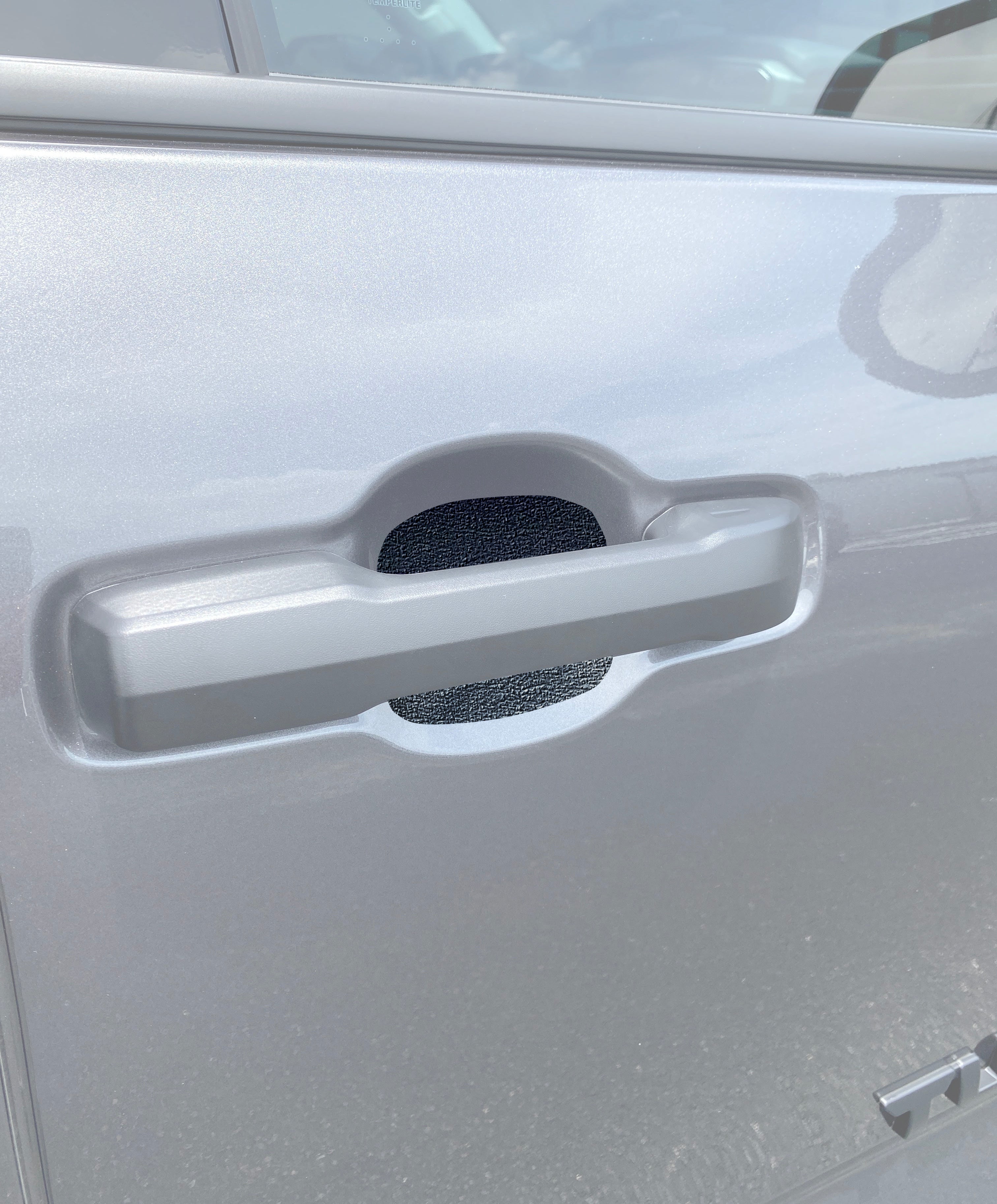 Textured protective door handle insert installed on a silver 2022-2024 Toyota Tundra, enhancing durability and style.