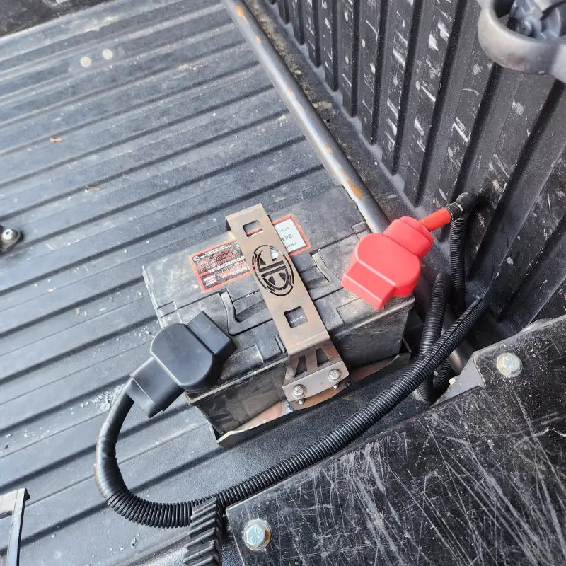 Installed battery in the truck bed using the Toyota Tacoma battery relocate kit, showcasing secure mounting and cable management.