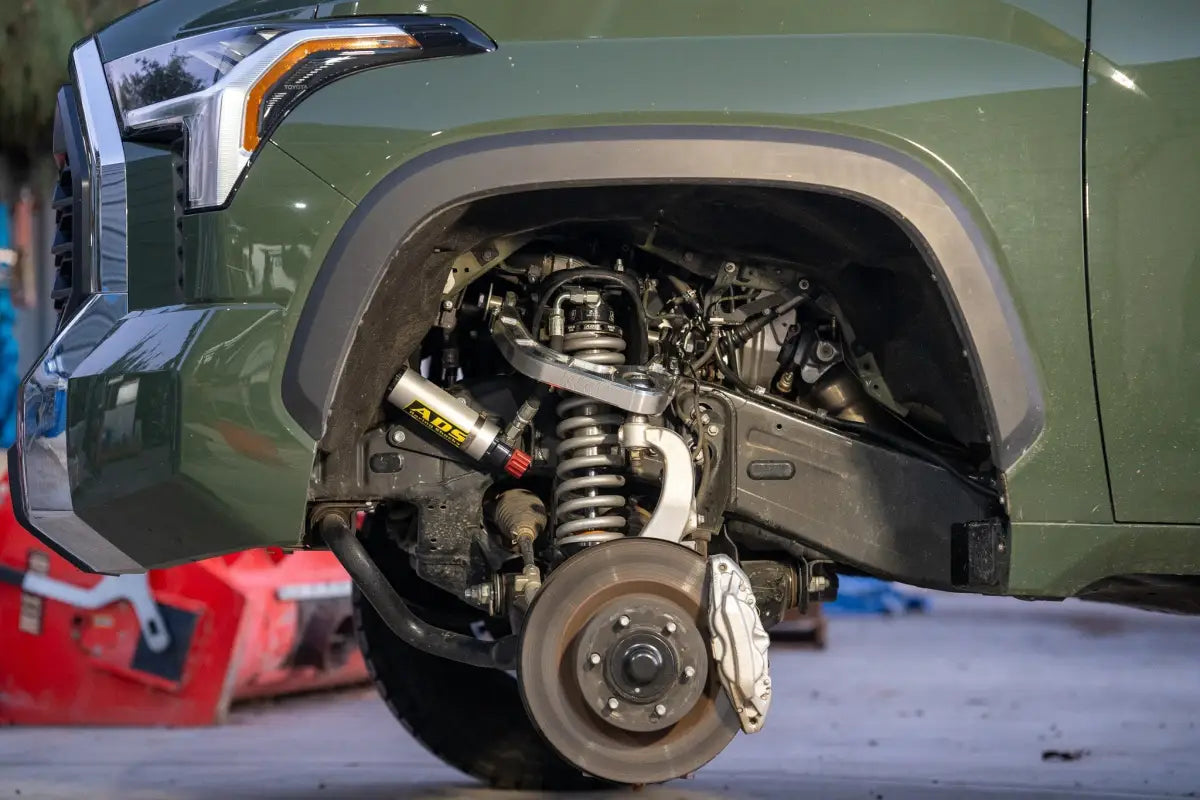 Green truck front suspension with kevlar reinforced, completely sealed, FEA analyzed Billet Uniball UCA for Silverado 1500
