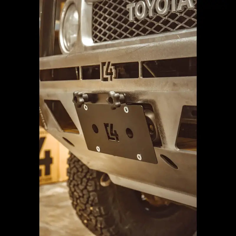 C4 Hawse License Plate Mount installed on a vehicle bumper, showcasing a durable black steel design and secure fit for off-road vehicles.
