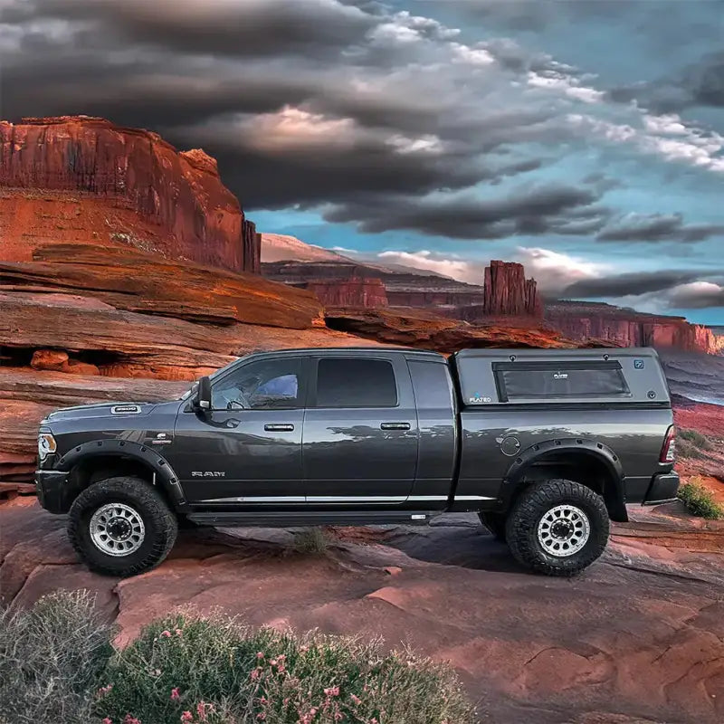 CAP Full-Size 6.4' Bed truck shell mounted on a pickup truck in a scenic desert landscape, emphasizing its rugged and outdoor-ready design.