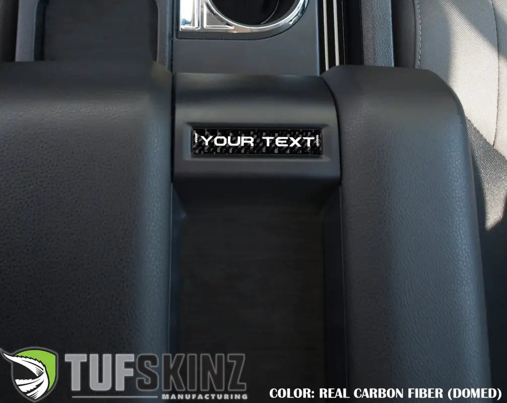 Customizable center console badge in real carbon fiber domed finish installed in a 2014-2021 Toyota Tundra, enhancing interior aesthetics.