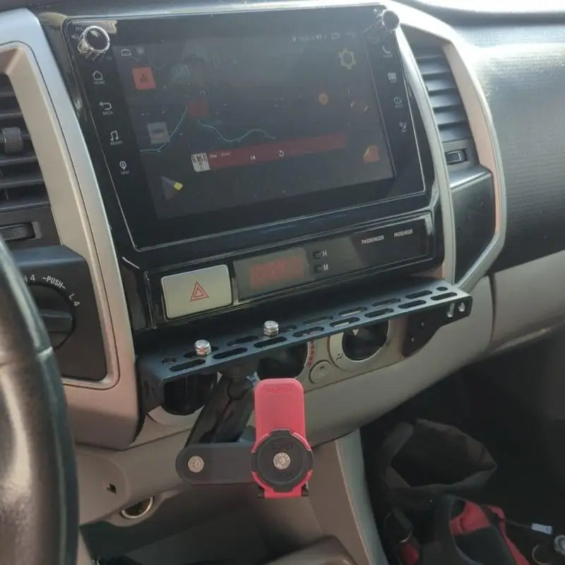 Toyota Tacoma modular accessory mount with a red phone holder attached, offering a secure and adjustable mounting solution.