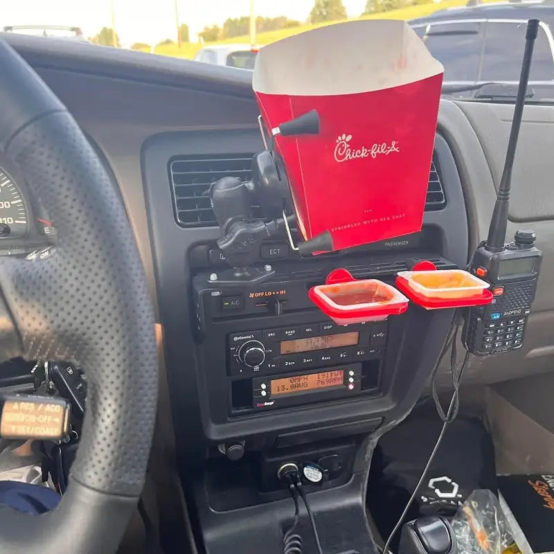3rd Gen 4Runner console mount in use with a fast-food holder and radio, demonstrating its versatility for everyday needs.