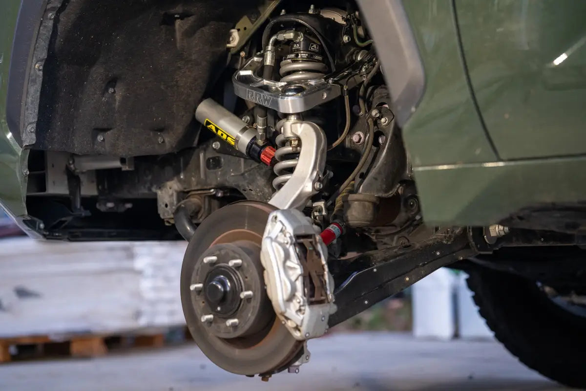 CNC Billet Upper Control Arm installed on a 2022+ Toyota Tundra suspension system, emphasizing enhanced wheel travel and droop angles.