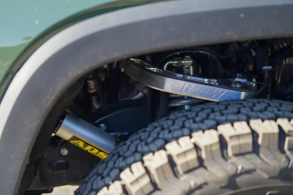 CNC Billet Upper Control Arm visible through the wheel well of a 2022+ Toyota Tundra, highlighting robust design and off-road capability.