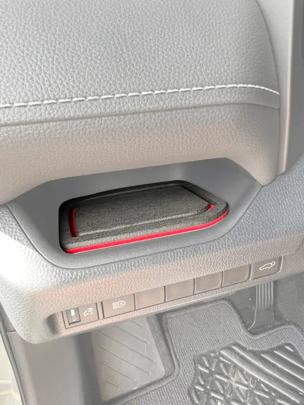 Driver side dash cubby foam insert with red trim installed in a 2019-2024 Toyota Rav4, enhancing interior decor and functionality.