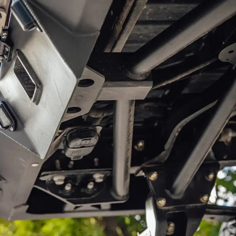 Underside view of DRT high clearance rear bumper on a Toyota Tacoma, highlighting steel construction and mounting points.