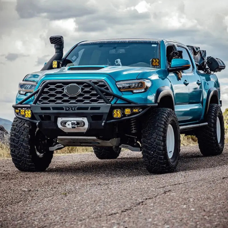 Blue 2016-2023 Toyota Tacoma with DRT Hybrid Front Bumper featuring integrated light mounts, winch compatibility, and rugged design.