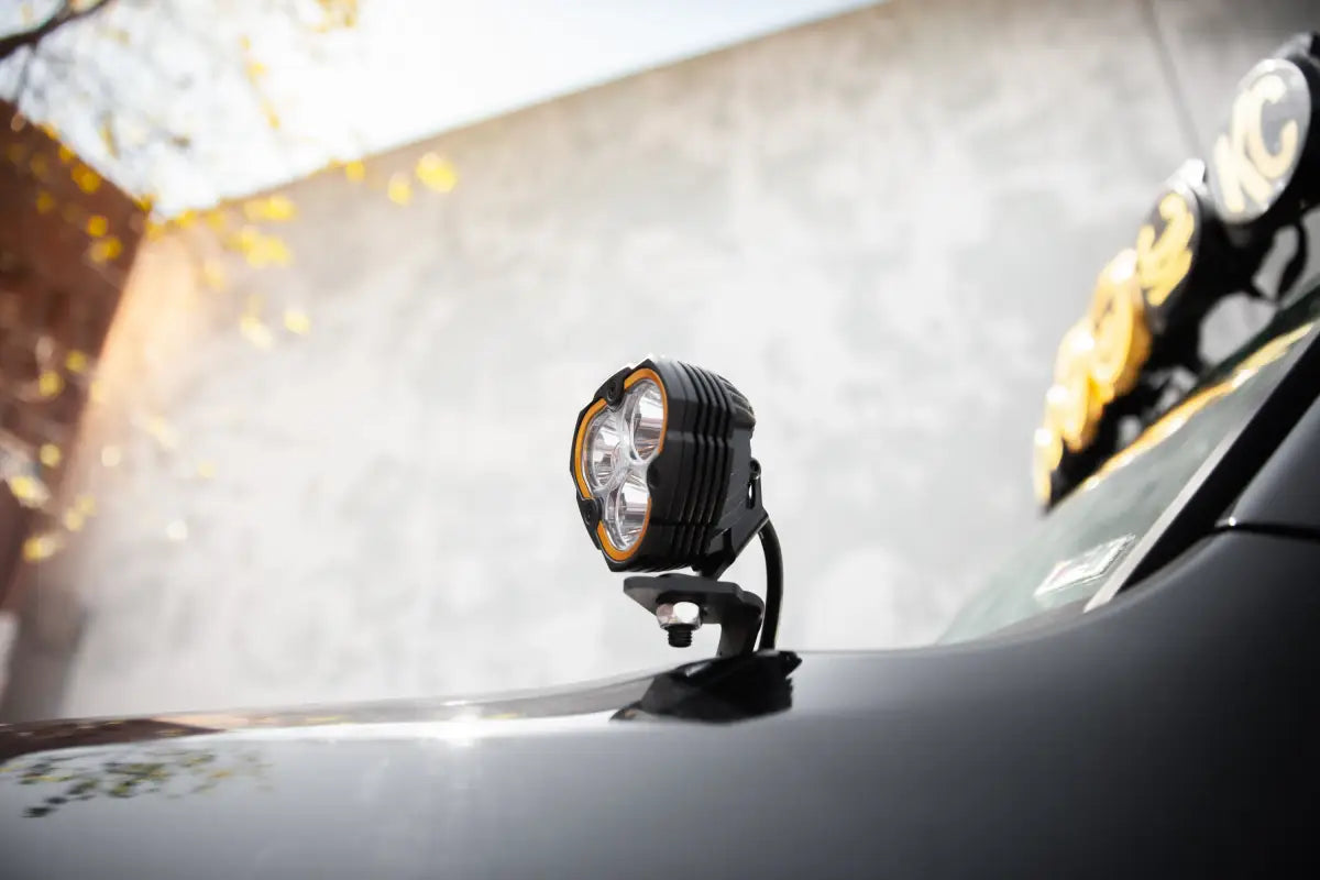 FLEX ERA® 3 LED light pod mounted on a vehicle hood, showcasing its compact design and amber-accented lens.