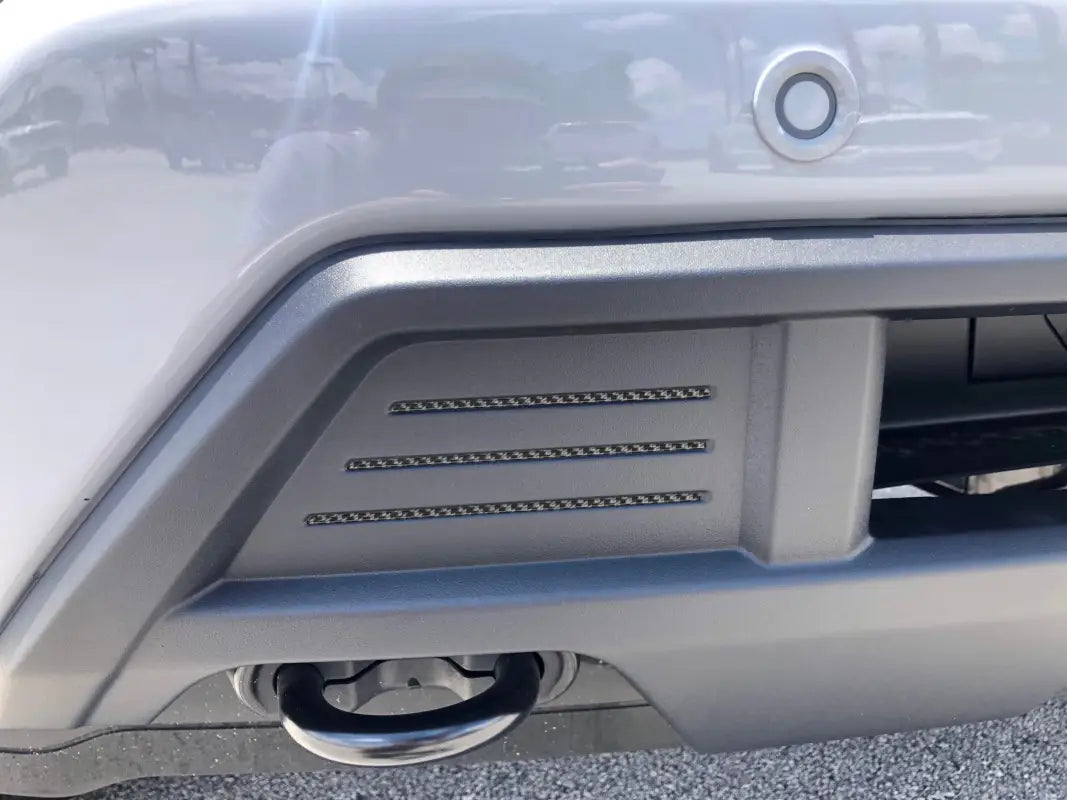 Silver car bumper with tow hook, designed as bumper line inserts for 2022-2024 Ford F-150 Roush