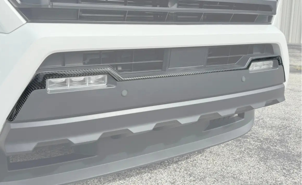 Front bumper upper line accent trim installed on a 2024 Toyota Tacoma, showcasing a sleek carbon fiber finish for enhanced exterior styling.