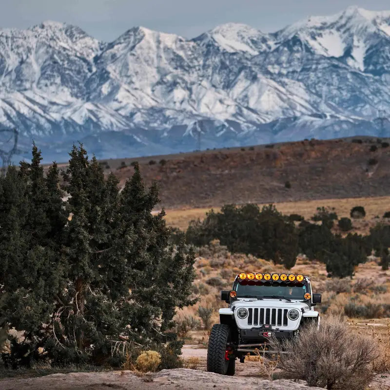 Off-road vehicle equipped with Gravity Titan 6" LED Spot Beam lights, set against a snowy mountain backdrop.